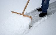 Symbolbild Winterdienst: Schneeschaufel im Einsatz