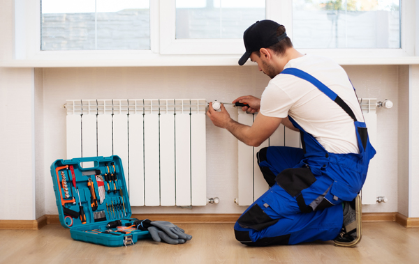 Symbolbild Steuerbonus für haushaltsnahe Handwerkerleistungen: Handwerker bei der Montage einer neuen Heizung