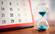 Symbolbild Fristablauf: Kalender und Sanduhr