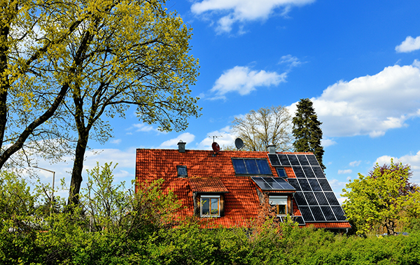 Haus mit Photovoltaik-Anlage und Bäumen