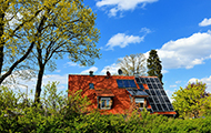 Haus mit Photovoltaik-Anlage und Bäumen