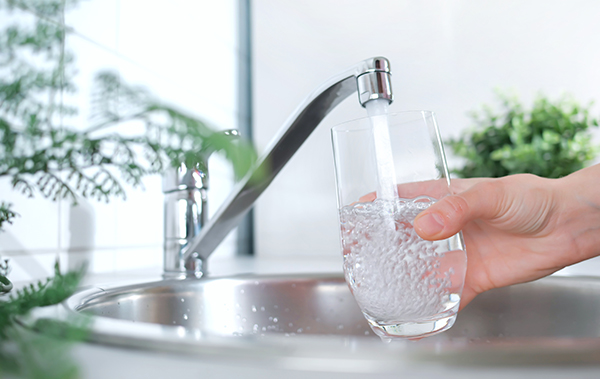 Symbolbild für Trinwasserversorgung: Wasser läuft in Glas