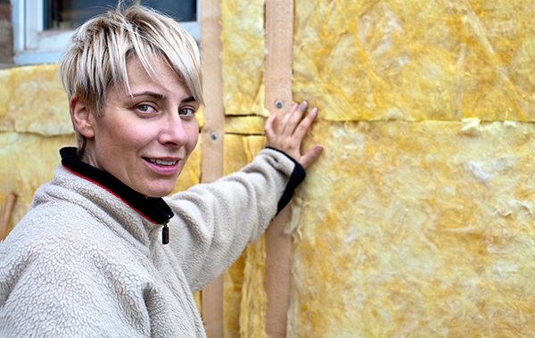 Symbolbild für Fassadendämmung: Frau betrachtet Wärmedämmung