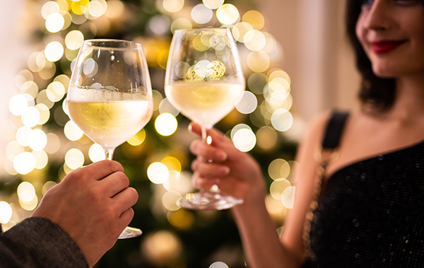 Motivbild für die rheinland-pfälzische Lebensart: Ein Mann und eine Frau stoßen mit Weißwein-Gläsern an. 
