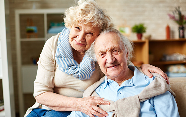 Symbolbild für Seniorenhaushalte: ein glückliches, älteres Pärchen in den eigenen vier Wänden