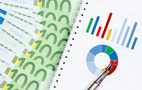 Symbol-Bild für die Kostenaufteilung in einer WEG: aufgefächerte 100-Euro-Scheine neben einer Statistik mit Kuchengrafik